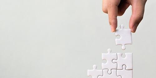 white jigsaw pieces being stacked up